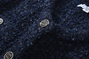 Dettaglio della trama in tweed intrecciato con tessuto blu navy e bottoni metallici