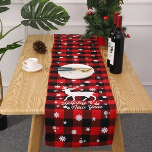 Détail d'un chemin de table de Noël à carreaux rouges et noirs avec renne