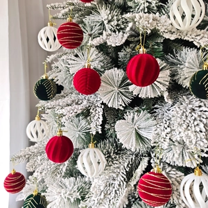Détails de boules de Noël en velours floqué rouge et vert avec motifs dorés sur sapin