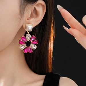 Primo piano di modella con orecchini a fiore con perle e strass rosa e bianchi