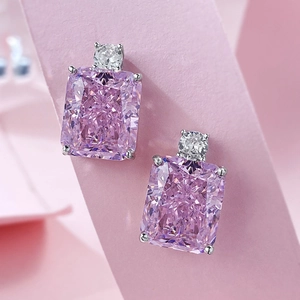 Macro shot of silver stud earrings featuring rectangular pink stones and clear accents