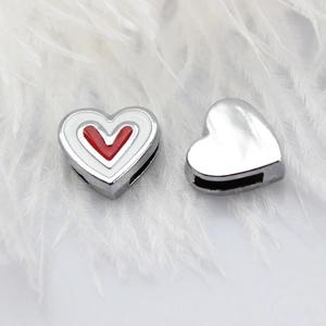 Macro detail of heart-shaped enamel charms for 8mm DIY wristbands on white feathers