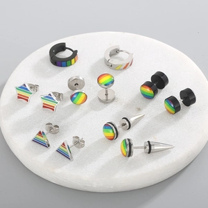 Macro shot of colorful rainbow stainless steel earrings on white marble coaster