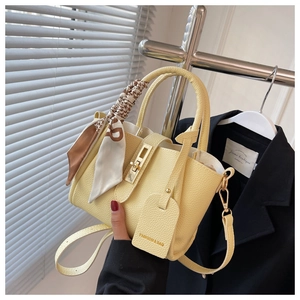 Détail du sac seau jaune citron en cuir grainé avec poignée en foulard de soie