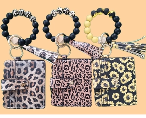 Detail view of silicone bead keychain bracelets with faux leather card holders in leopard print