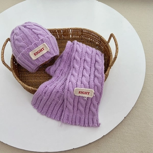 Detailansicht des lila Zopfmusters und Stoffaufnäher am Kinder-Winterstrickset