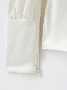 Détail de la manche d'une chemise en satin avec fermeture éclair et tissu soyeux