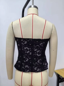 Détail macro du haut bustier en dentelle noire avec motif floral sur tissu élastique