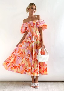 Detail of off-shoulder printed maxi dress with puff sleeves and layered tiered skirt