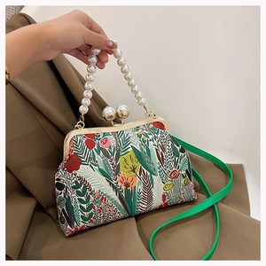 Details einer Vintage-Handtasche mit Blumenmuster, Perlenkordel und Goldverschluss