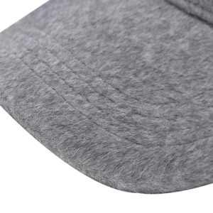 Détail macro d'une casquette d'hiver en peluche grise montrant les coutures et la texture