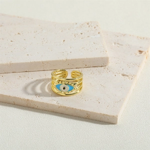 Adjustable golden evil eye ring featuring a unique four-strand band on marble background