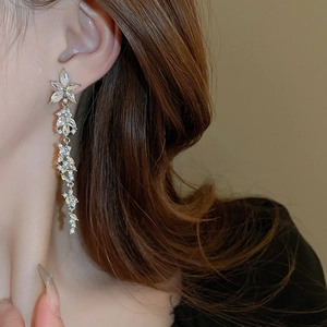 Detail of silver long tassel earrings with sparkling flower and leaf zircon crystals