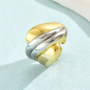 Macro detail of chunky two-tone gold and silver twisted wave ring with high-polish finish