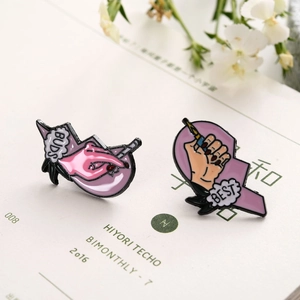 Detail shot of heart-shaped enamel pins featuring pink and black colors on a floral backdrop