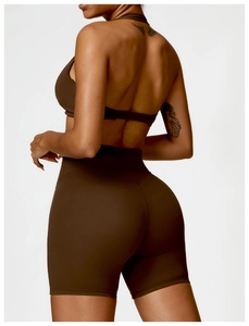 Detail of dark brown open-back halter yoga top and high-waisted shaping sports leggings