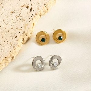 Detail of geometric stainless steel earrings with green and clear inlaid gemstones