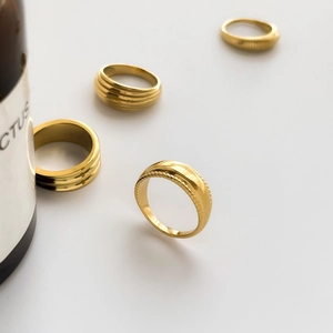 Set of four gold-plated vintage rings with ribbed textures and smooth minimalist design