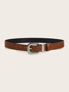 Detail of brown leather belt with embossed geometric patterns and vintage silver buckle