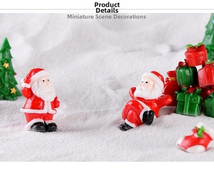 Close-up of resin Santa Claus and Christmas tree miniature figurines in snow scene