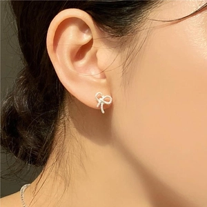 925 sterling silver bow knot earrings with twisted rope texture on a female model