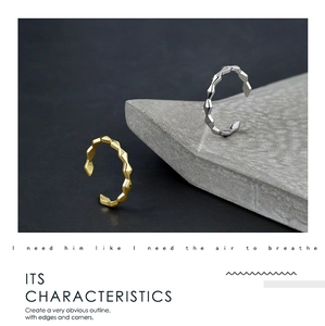 Detailed close-up of geometric gold and silver rings with faceted surface design