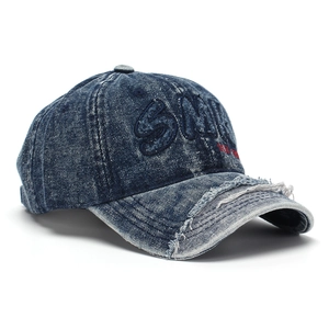 Detail of vintage blue denim baseball cap with 3D embroidery and distressed brim