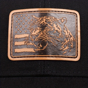 Macro view of leopard leather patch and starry flag embroidery on vintage trucker hat