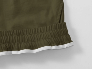 Macro detail of elastic waistband and white trim on olive green cargo shorts