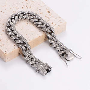Silver iced out Cuban link bracelet on beige stone display with hip hop style design