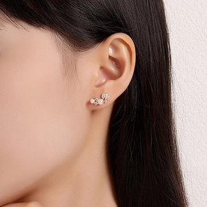 Detail of S925 silver pearl stud earrings with zircon leaf clusters on model side profile