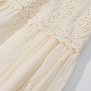 Macro shot of French lace patchwork and eyelet embroidery details on a cotton shirt
