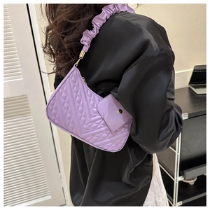 Detail of purple quilted shoulder bag with pleated strap and matching mini pouch accessory