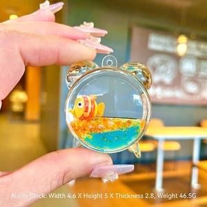 Alarm clock shaped liquid keychain with clownfish floating in blue oil and orange glitter
