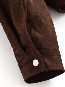 Macro shot of dark brown suede jacket cuff with silver button and premium stitching