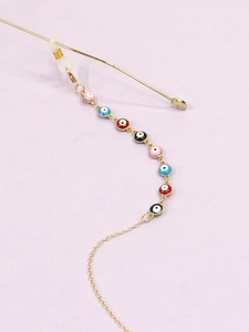 Detail of colorful evil eye beads on a golden metal glasses chain with silicone loops