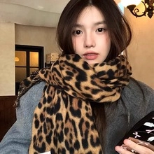 Close-up of leopard print scarf featuring thick knit fabric on a model in a natural setting