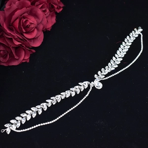 Close-up of silver bridal headpiece with leaf-shaped rhinestones and red roses