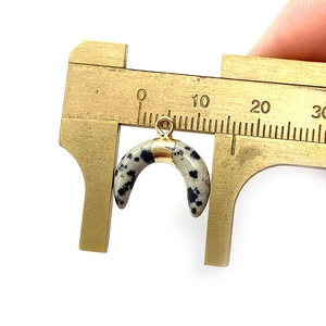 Detailed macro view showing the 18mm width of the crescent moon stone pendant with caliper