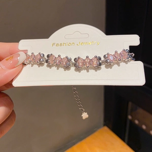 Detail of adjustable pearl bracelet with pink oval zircon and bear charm tail chain