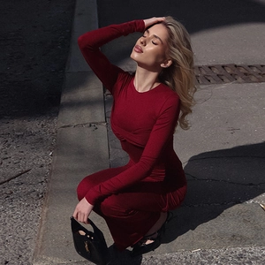 Photo street style d'une robe rouge ajustée à manches longues avec détails froncés
