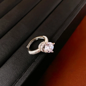 Gros plan d'une bague réglable en argent avec un grand zircon sur présentoir noir