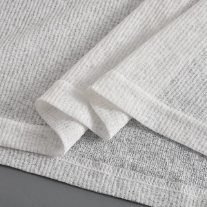 Macro shot of white knitted mesh fabric texture and high-quality hem stitching details