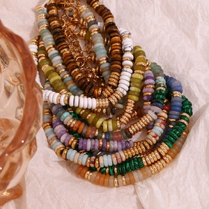 Détail de bracelets en perles colorées avec séparateurs dorés 18K et chaînes de rallonge