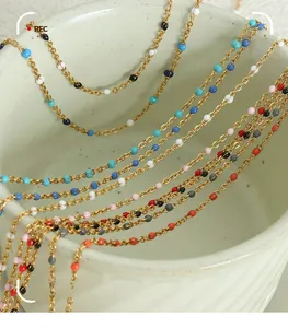 Detail shot of colorful enamel beads on a delicate gold plated stainless steel necklace chain