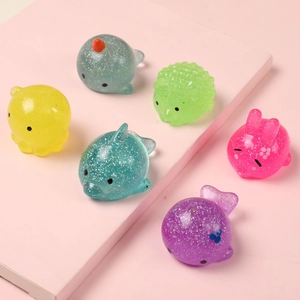 Set of 6 colorful glitter ocean animal squishy stress relief toys on a pink background