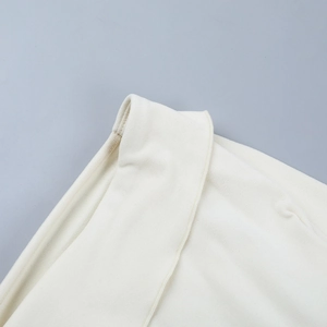 Gros plan sur un tricot blanc cassé montrant les coutures de précision et la texture