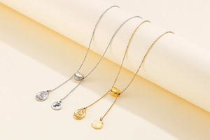 Detail of adjustable heart slider and dual coin pendants on gold and silver necklaces