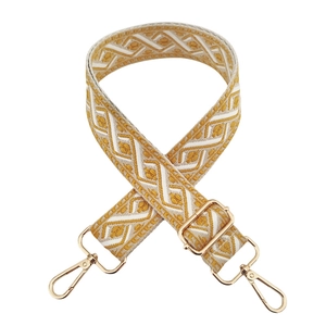 Detail of yellow and white jacquard bag strap with ethnic patterns and gold metal hardware