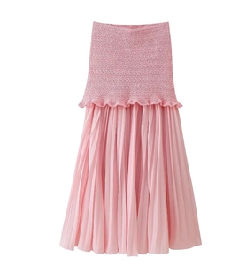 Détail du haut en tricot rose et de la jupe longue à empiècement en mousseline plissée